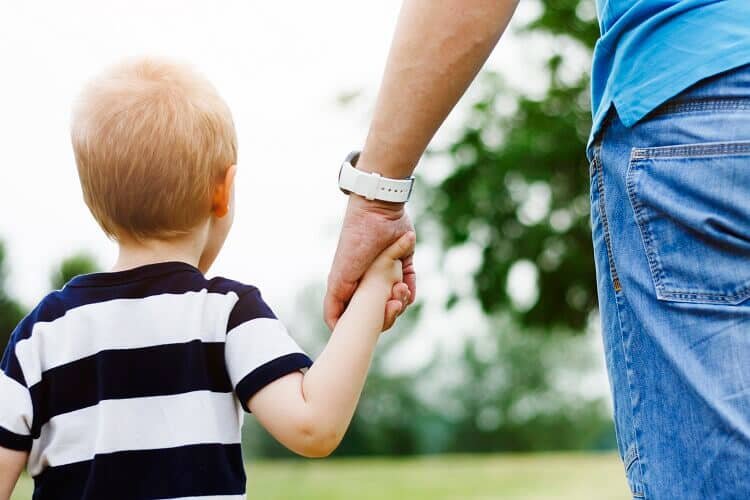 parent holding a child's hand